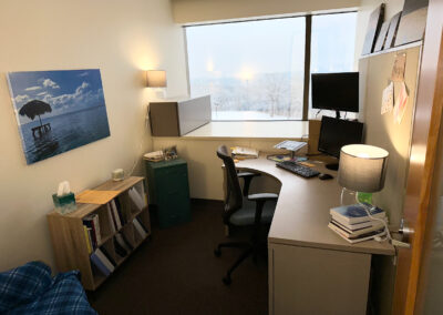 Picture of counseling office with desk, chairs, bookshelf and window