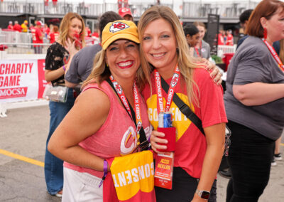 Two individuals at Chiefs Charity Game tailgate suite.