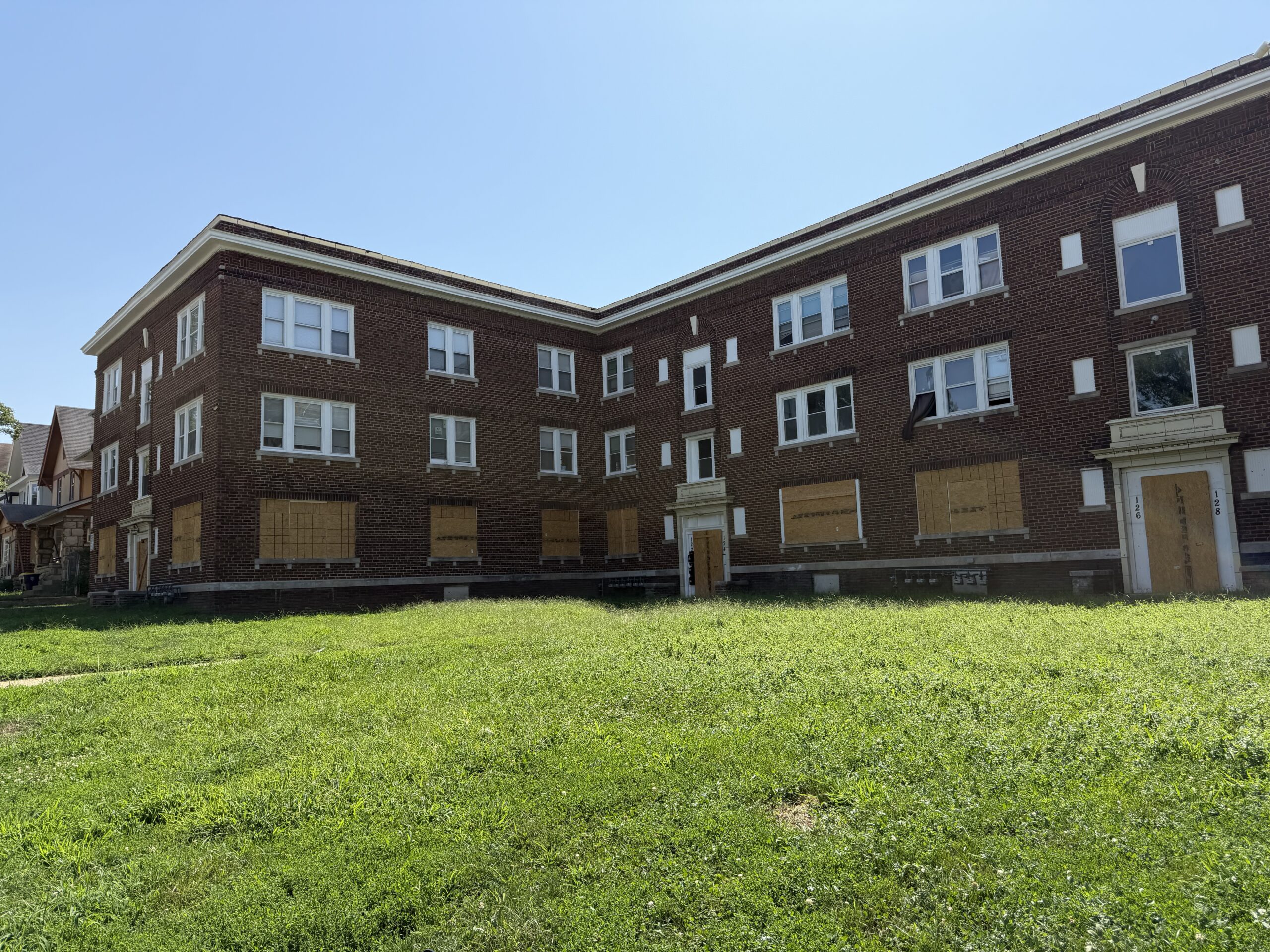 North Lawn apartments exterior North Lawn Apartment building with first floor windows and doors boarded up